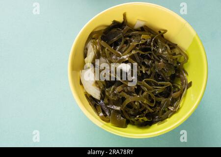 salade avec algues et oignons dans une assiette sur une table Banque D'Images