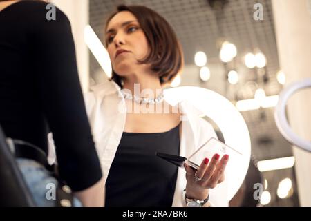 l'artiste maquilleur applique le maquillage du mannequin au salon de beauté avant les vacances Banque D'Images