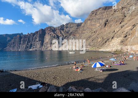 Los Gigantes, Tenerife, Iles Canaries, Espagne - 21 septembre 2022: Les gens se détendent sur la pittoresque plage de Los Guios parmi les falaises majestueuses Banque D'Images