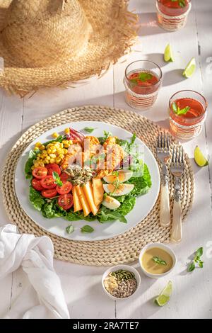 Salade maison servie dans le jardin avec limonade. Salade de poulet, légumes et fruits. Banque D'Images
