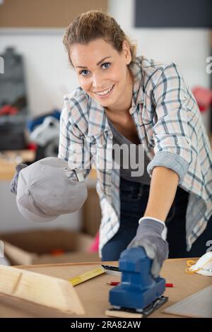 artisan professionnel et talentueux souriant et tenant l'expéditeur électrique Banque D'Images