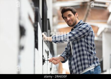 client man utilisant un terminal de poste en libre-service automatisé Banque D'Images