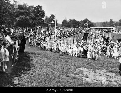New York, New York : c. 1928 plus de 100 000 élèves de l'école du dimanche de Brooklyn de 360 églises ont défilé dans diverses parties du quartier lors du défilé anniversaire de 102nd de l'Union scolaire du dimanche de Brooklyn. Une partie de la parade passe devant le stand de revue dans Prospect Park. Banque D'Images