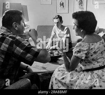 Boston, Massachusetts: 1956 Un adolescent regarde ses parents boire des cocktails. Banque D'Images