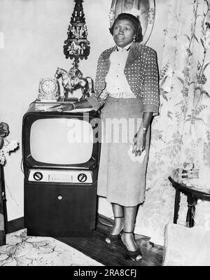 San Francisco, Californie: c. 1953 Une femme d'âge moyen est fière de son téléviseur Admiral installé dans son salon. Banque D'Images