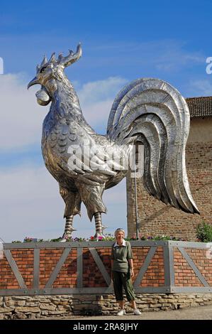 Femme devant une sculpture de coq, Bresse, Ain, Rhône-Alpes, France Banque D'Images