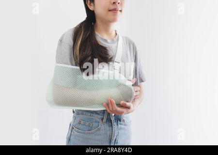 Jeune femme blessée à la main portant une attelle, bras cassé, isolée sur fond blanc Banque D'Images