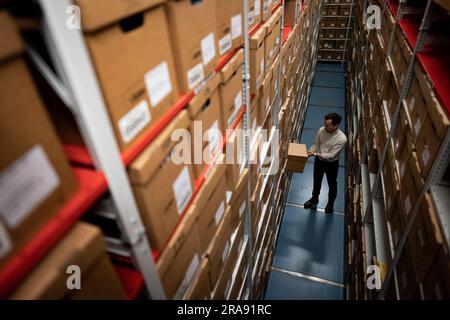 Laurence Ward, responsable des services numériques pour les Archives métropolitaines de Londres (LMA), retire une boîte de l'installation de stockage des plus grandes archives historiques du Royaume-Uni. Avec plus de 100km livres, cartes, photographies, films et documents datant de 1067 détenus dans des salles fortes, le LMA est le principal dépôt d'archives du gouvernement local pour la région du Grand Londres, y compris la City de Londres et est le plus grand bureau de disques du comté au Royaume-Uni. Date de la photo: Mardi 27 juin 2023. Banque D'Images