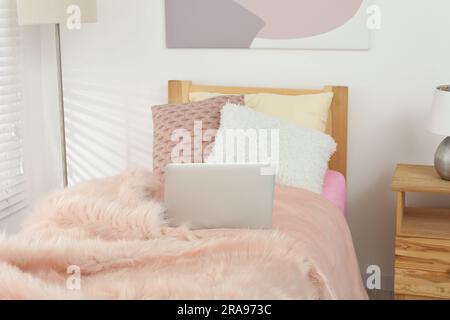 Intérieur élégant de la chambre de l'adolescent avec lit confortable et ordinateur portable Banque D'Images