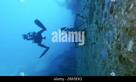 Plongée plongeur nager et filmer le long du pont du ferry Salem Express Shipwreck, Red Sea, Safaga, Egypte Banque D'Images