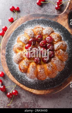 Délicieux gâteau de cerisier sur une planche en bois sur la table. Vue verticale du dessus Banque D'Images