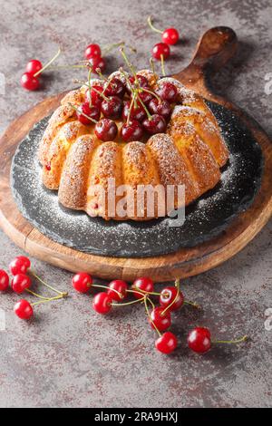 Délicieux gâteau de cerisier sur une planche en bois sur la table. Verticale Banque D'Images