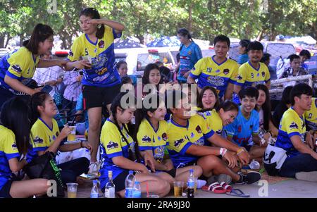 Une équipe de jeunes hommes gais, femmes, garçons, filles, joueurs de volley-ball sourient pour un photographe local et attendent de jouer au volley-ball un dimanche après-midi à Laem Chabang Port, province de Chonburi, Thaïlande Banque D'Images