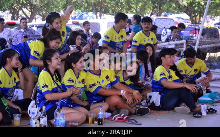 Une équipe de jeunes hommes gais, femmes, garçons, filles, joueurs de volley-ball sourient pour un photographe local et attendent de jouer au volley-ball un dimanche après-midi à Laem Chabang Port, province de Chonburi, Thaïlande Banque D'Images