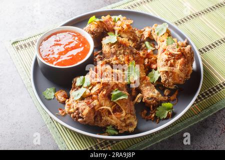 Thai Street Food Hatyai Fried Chicken avec sauce Chili douce et oignons croustillants gros plan sur une assiette sur la table. Horizontale Banque D'Images