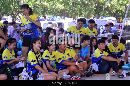 Une équipe de jeunes hommes gais, femmes, garçons, filles, joueurs de volley-ball sourient pour un photographe local et attendent de jouer au volley-ball un dimanche après-midi à Laem Chabang Port, province de Chonburi, Thaïlande Banque D'Images