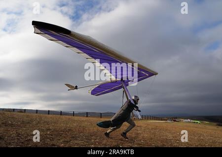 Le pilote de planeur suspendu tourne rapidement sur une pente avant d'être aéroporté. Sport extrême Banque D'Images