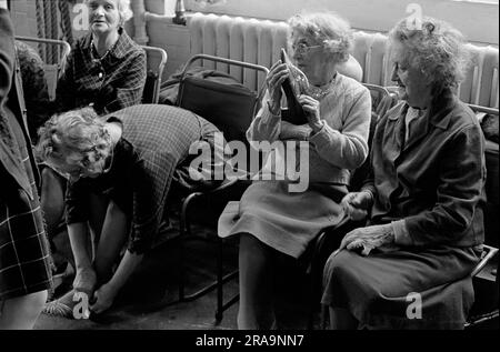 Darby et Joan Club. Se préparer à vérifier les chaussures lors d'un cours de danse de l'après-midi à vue aveugle et partielle pour les personnes âgées à l'Institut Battersea. Battersea, Londres, Angleterre vers 1970. 1970S ROYAUME-UNI HOMER SYKES Banque D'Images