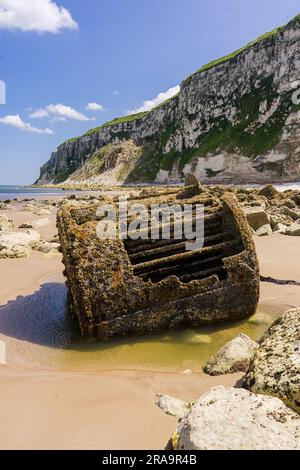 Rouille de la chaudière de l'ancien navire au pied des falaises de craie, au bout de Speeton Sands, dans la baie de Filey. Parmi les rochers au pied des falaises est thi Banque D'Images