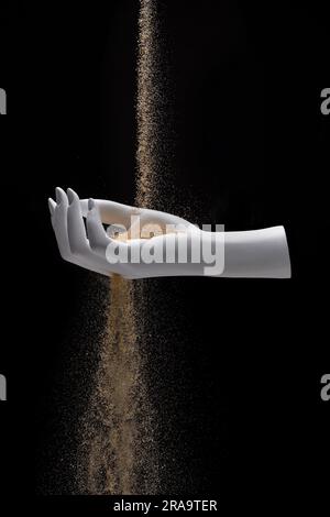 Le temps glisse loin - le sable tombe à travers la main Banque D'Images