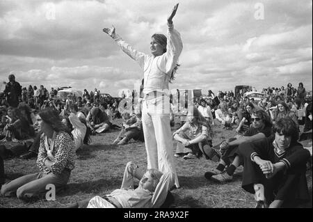 Festival gratuit de Stonehenge au solstice d'été, le 21 juin. New age hippies célébrant la musique un groupe live est sur scène un Pop Festival Wiltshire, Angleterre juin 1976. ANNÉES 1970 ROYAUME-UNI HOMER SYKES Banque D'Images