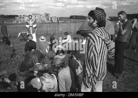 Les festivaliers écoutent un prêtre qui est venu pour tenir un service d'église en plein air. Stonehenge Free Festival au solstice d'été, Wiltshire, Angleterre juin 1976. 1970S ROYAUME-UNI HOMER SYKES Banque D'Images