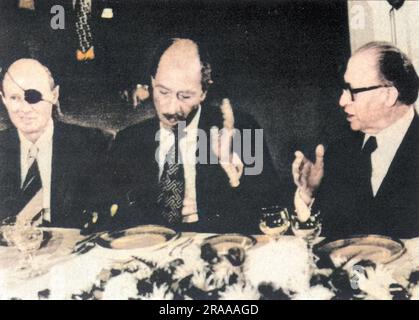 Anwar Sadat d'Égypte(1918-1981) lors d'un dîner d'État en son honneur, assis entre Moshe Dayan(1915-1981) et le Premier ministre israélien Menachem Begin(1913-1992). Sadate est devenu le premier dirigeant arabe à avoir mis les pieds en Israël au cours de ses 29 années d'existence lorsqu'il est arrivé à tel Aviv au début de sa visite de deux jours. Date: Nov-77 Banque D'Images