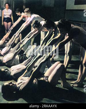 Santé et beauté - un cours d'exercice matinal à Harrington Road, Londres, sous la direction de Helen Stack (cousine de Prunella Stack) pour la Women's League of Health and Beauty, à l'Académie de musique et d'art dramatique de Londres Ici, les jeunes femmes démontrent « la séquence Croydon », ainsi appelée, parce que deux filles de Croydon l'ont inventée. Date: 1938 Banque D'Images