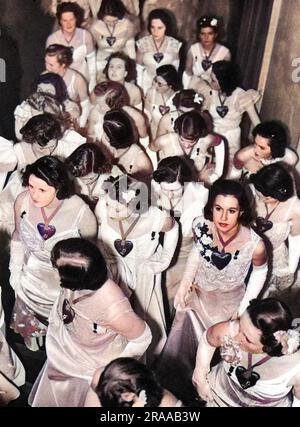 Tout en blanc avec des coeurs en satin écarlate autour de leur cou (un cadeau de Schiaparelli), debutantes au bal de la Reine Charlotte de 1939. Date: 1939 Banque D'Images