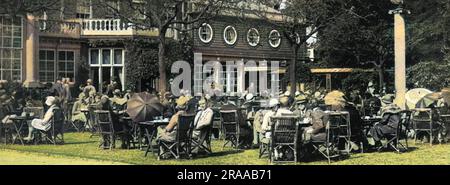 Une scène typique à l'heure du thé à Ranelagh sur un polo samedi, montrant la société intelligente assis à des tables en plein air. Autrefois l'ancien Kit-Kat Club, Ranelagh, à Barnes dans le sud-ouest de Londres était l'un des endroits populaires pendant la saison de Londres beaucoup fréquentés par la société. Date: 1928 Banque D'Images