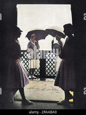 Les dames en double finale au Cumberland Club Tournament, prennent refuge lors d'une douche à effet pluie en 1932. Date: 1932 Banque D'Images