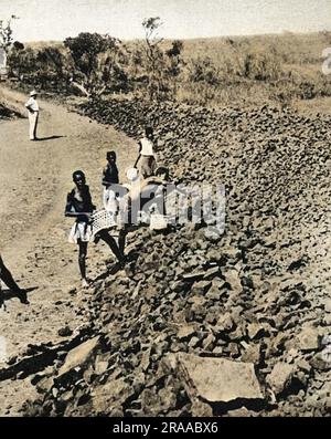 Au Congo belge (Zaïre), les travailleurs locaux collectent des pierres extraites à proximité afin de construire un barrage temporaire sur le fleuve Dangu. Le but était de créer un lac pour permettre au bateau-avion Imperial Airways « Corsair » de décoller. Le Corsair avait effectué un atterrissage forcé en mars 1939, et après une tentative infructueuse de décollage en juin 1939, il a finalement été réparé et retourné en Angleterre en janvier 1940 Date: Jan-40 Banque D'Images