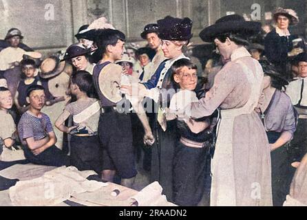 Des infirmières bénévoles pratiquant leurs techniques de bandage sur des enfants à l'hôtel de ville de Kensington peu après le début de la première Guerre mondiale. Date: 1914 Banque D'Images