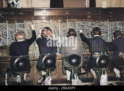 Femmes téléphonistes à un bureau de Londres avec des casques en étain, pendant la Seconde Guerre mondiale Date: C.1939 Banque D'Images