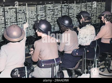 Femmes téléphonistes à un bureau de Londres avec des casques en étain, pendant la Seconde Guerre mondiale Date: C.1939 Banque D'Images