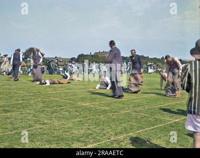 Les pères sportifs participent à une course de sacs spécialement conçue pour eux lors d'une journée de sport scolaire à Seaford, dans le Sussex. Plusieurs d'entre eux sont tombés dessus, ou sont en train du faire. Date: 1934 Banque D'Images