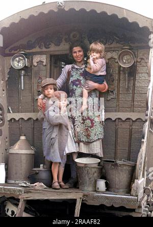 Une gitane avec trois enfants, debout à l'extérieur de leur caravane. Banque D'Images