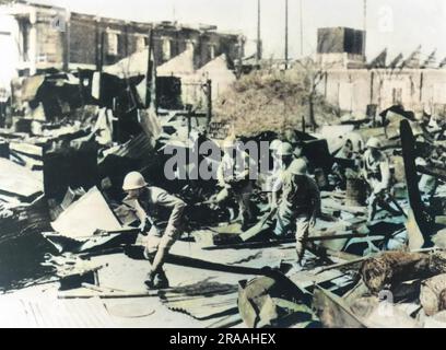 Après les bombardements aériens et les bombardements de l'artillerie à Shanghai, les troupes japonaises se déplacent dans la ville en ruines, avec des baïonnettes fixées, pour éponger la résistance chinoise Date: 1937 Banque D'Images