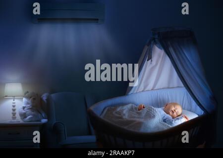 Climatiseur dans la chambre de bébé. Climatisation réglable dans la chambre des enfants. Bébé enfant dans le berceau sous la brise de l'air frais. Température confortable, sommeil sain Banque D'Images