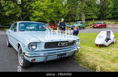 East Lothian, Écosse, Royaume-Uni, 2 juillet 2023. Roues d'antan : la visite annuelle de l'Association écossaise des passionnés de véhicules emmène les propriétaires de véhicules d'époque à travers la campagne jusqu'au parc pittoresque de Lennoxlove House. Photo : une Ford Mustang vintage 1966 et un vélo Sinclair C5. Crédit : Sally Anderson/Alamy Live News Banque D'Images