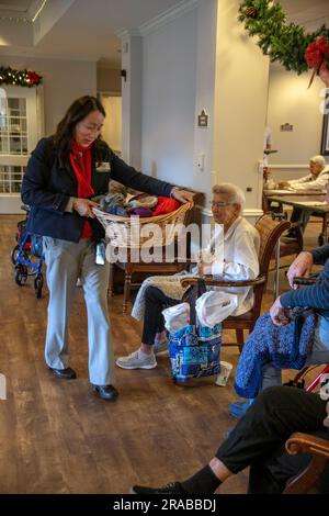 Un membre bénévole hispanique d'un groupe catholique de tricotage d'église distribue un panier de leur travail aux résidents de maisons de soins infirmiers à San Juan Capistrano, C. Banque D'Images