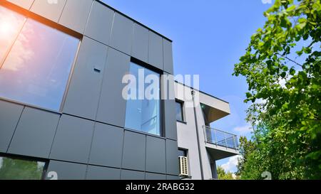 Façade en graphite et grandes fenêtres sur un fragment d'immeuble de bureaux contre un ciel bleu. Façade moderne en aluminium avec fenêtres. Banque D'Images