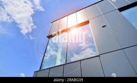 Façade en graphite et grandes fenêtres sur un fragment d'immeuble de bureaux contre un ciel bleu. Façade moderne en aluminium avec fenêtres. Banque D'Images