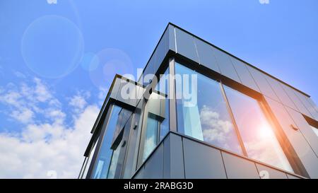 Façade en graphite et grandes fenêtres sur un fragment d'immeuble de bureaux contre un ciel bleu. Façade moderne en aluminium avec fenêtres. Banque D'Images