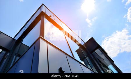 Façade en graphite et grandes fenêtres sur un fragment d'immeuble de bureaux contre un ciel bleu. Façade moderne en aluminium avec fenêtres. Banque D'Images