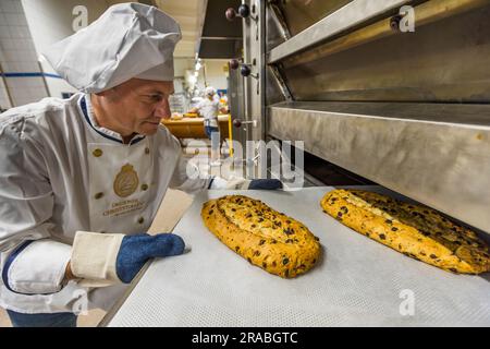 Production d'un Christstollen Dresde original à Dresde, Allemagne. Maître boulanger Tino Gierig du Schutzverband Dresdner Stollen sort le Stollen du four après 60 minutes de cuisson Banque D'Images