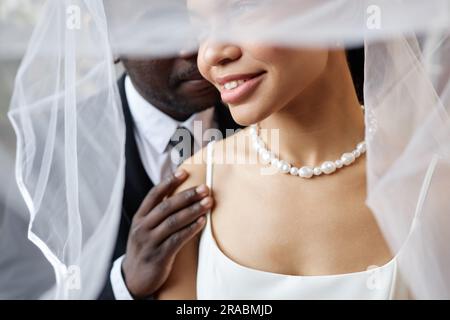 Gros plan portrait de couple noir comme épouse affectueuse et marié embrassant sous le voile Banque D'Images