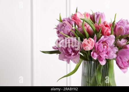 Beau bouquet de fleurs de tulipe colorées dans un vase sur fond blanc Banque D'Images