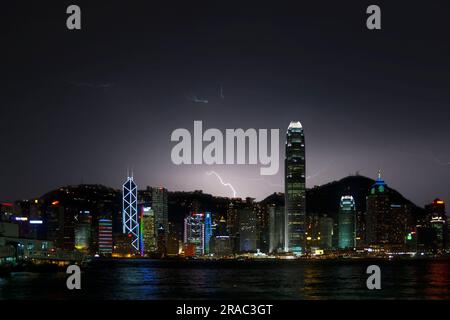 Hong Kong S.A.R., Hong Kong - 18 août 2007 : l'île de Hong Kong la nuit pendant un orage avec un éclair frappant derrière l'île. La scène i Banque D'Images