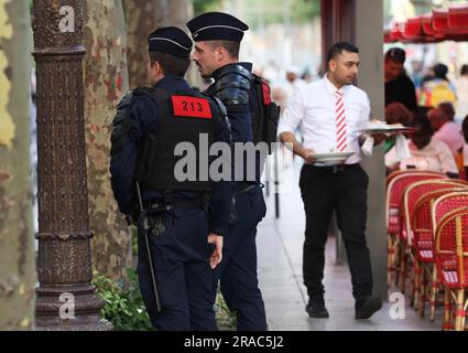 Paris, France. 2nd juillet 2023. Des policiers français patrouillent dans la célèbre avenue des champs-Élysées à Paris, en France, en 2 juillet 2023. Au moins 719 personnes ont été arrêtées pendant la nuit de samedi à dimanche en France, la cinquième nuit de violence nationale déclenchée par le meurtre d'un adolescent par un policier, a déclaré dimanche le ministère de l'intérieur français. Selon le ministère, 45 policiers et gendarmes ont été blessés, tandis que 577 véhicules et 74 bâtiments ont été brûlés. Credit: Gao Jing/Xinhua/Alamy Live News Banque D'Images